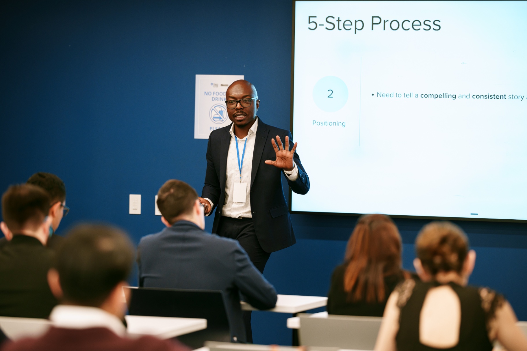 Mukhtar Kadiri presenting a five-step positioning process to a seated audience