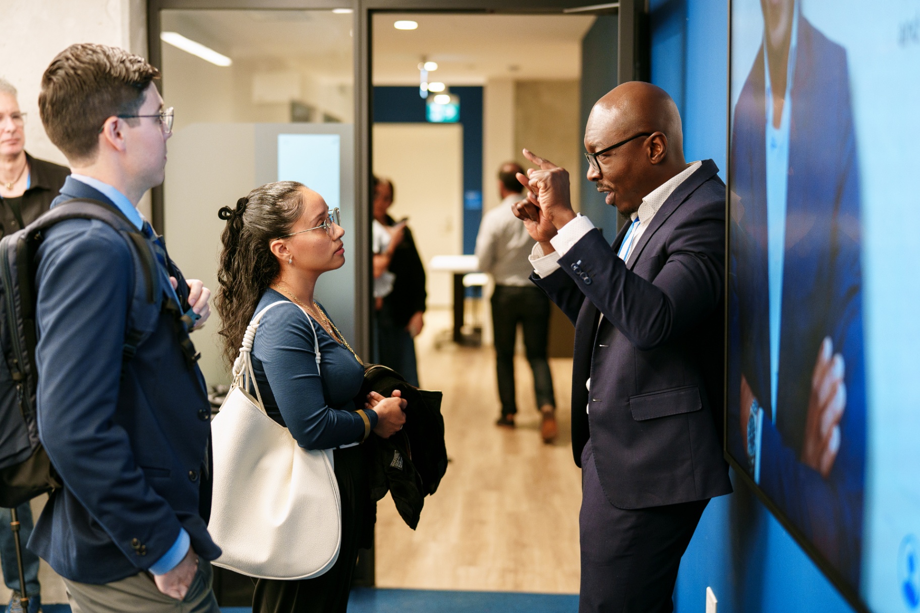 Mukhtar Kadiri talking with two attendees after a session